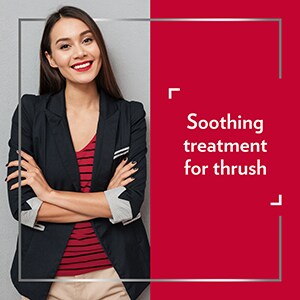 Smiling young woman wearing smart clothes with her arms crossed, happy after Canesten treatment, with the caption ‘’ Soothing treatment for thrush’’